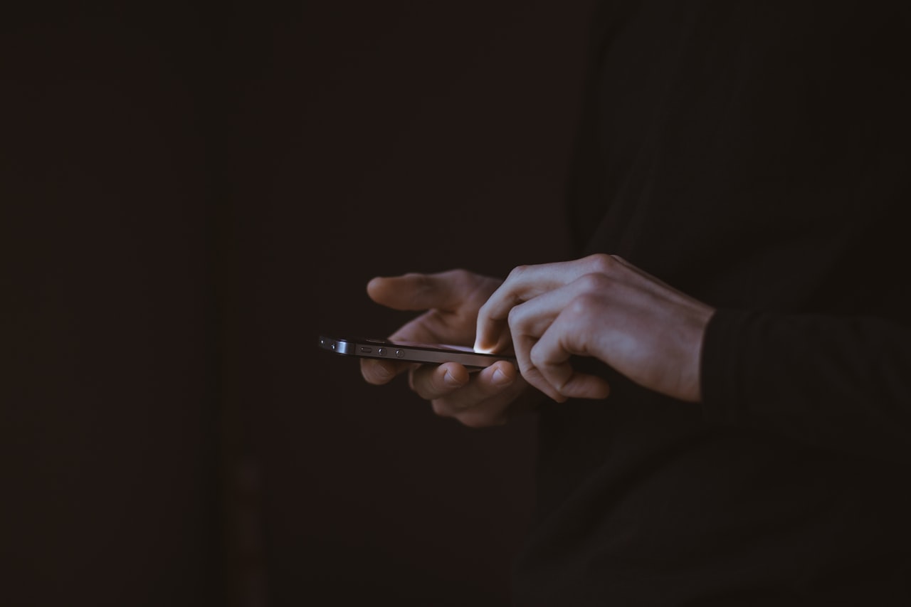 Persona escribiendo un mensaje de WhatsApp desde el móvil en un entorno tranquilo