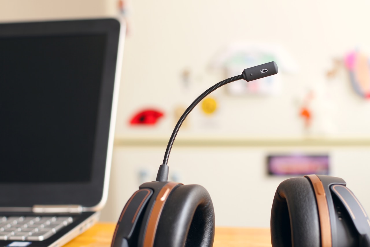 Persona de atención al cliente atendiendo con auriculares delante de un ordenador