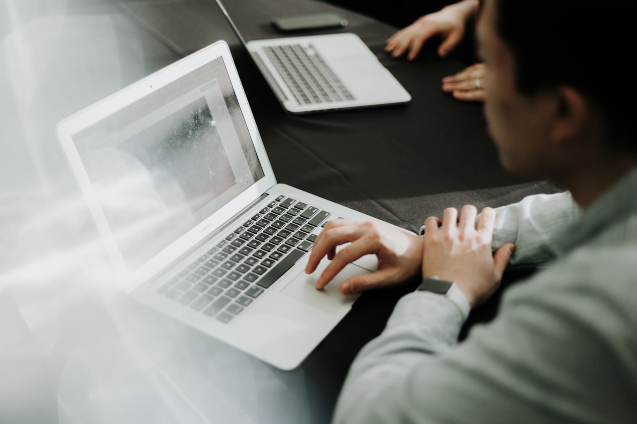 Profesional trabajando con un portátil en una oficina, revisando y analizando los datos del lead