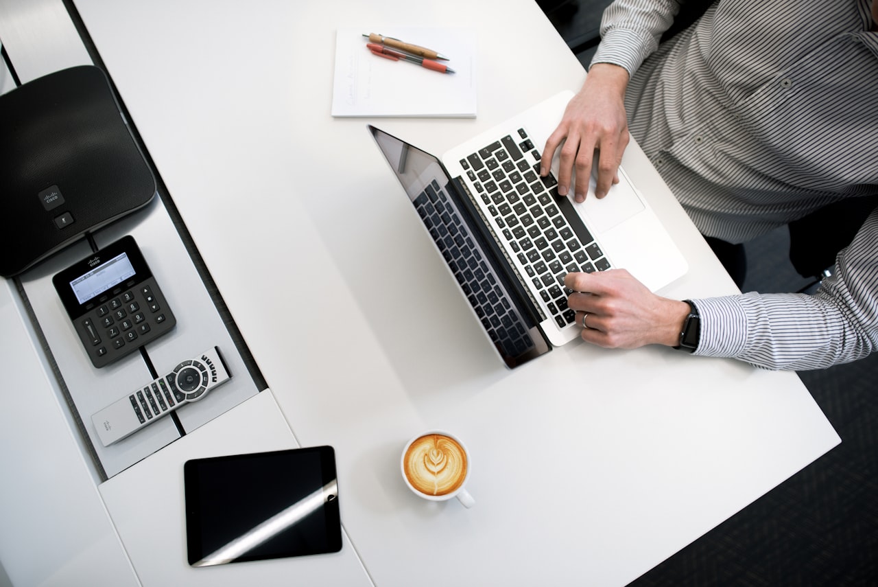 Profesional trabajando con un portátil en una oficina, programando el calendario de envíos