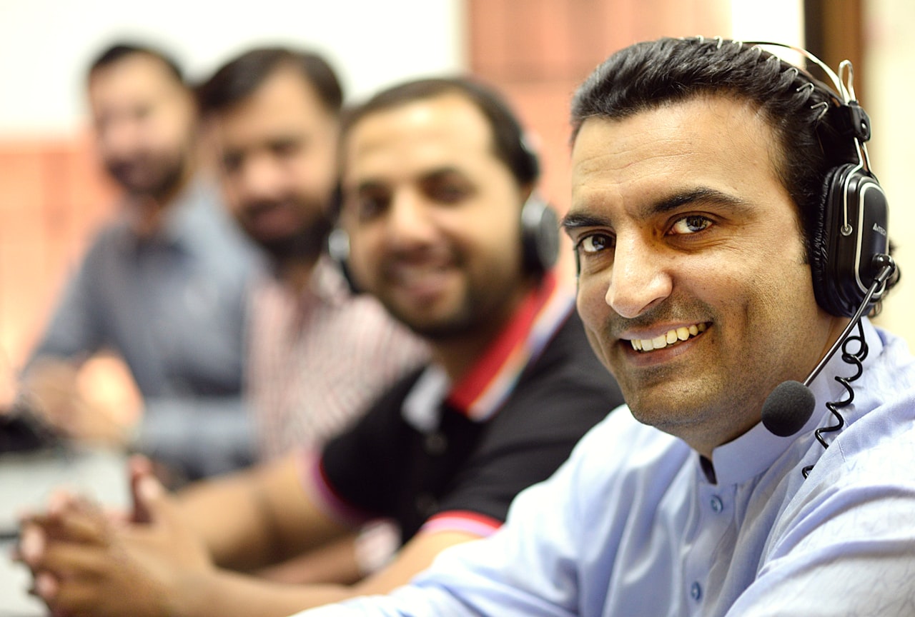 Equipo de atención al cliente con auriculares sonriendo durante su jornada